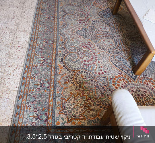 שטיח צבעוני על רצפה ליד ספה ושולחן עץ